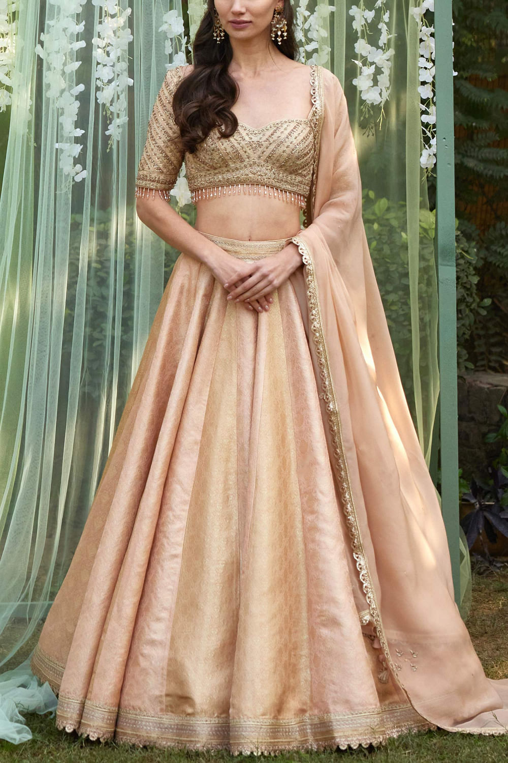 Sue Mue - PURNIMA This badami coloured hand woven tissue brocade lehenga  has been set in an exclusive Sue Mue pattern. It consists of a deep V-neck  blouse and a kalidar skirt